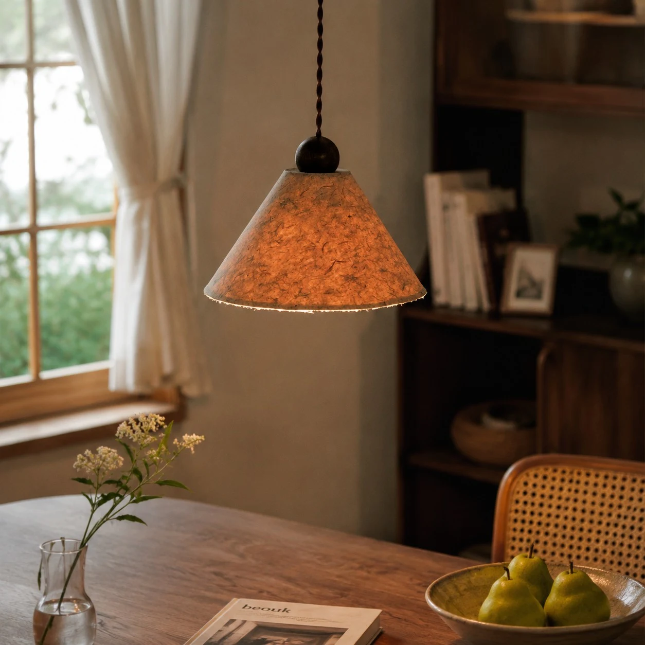 Warm natural paper pendant lamp beside a window