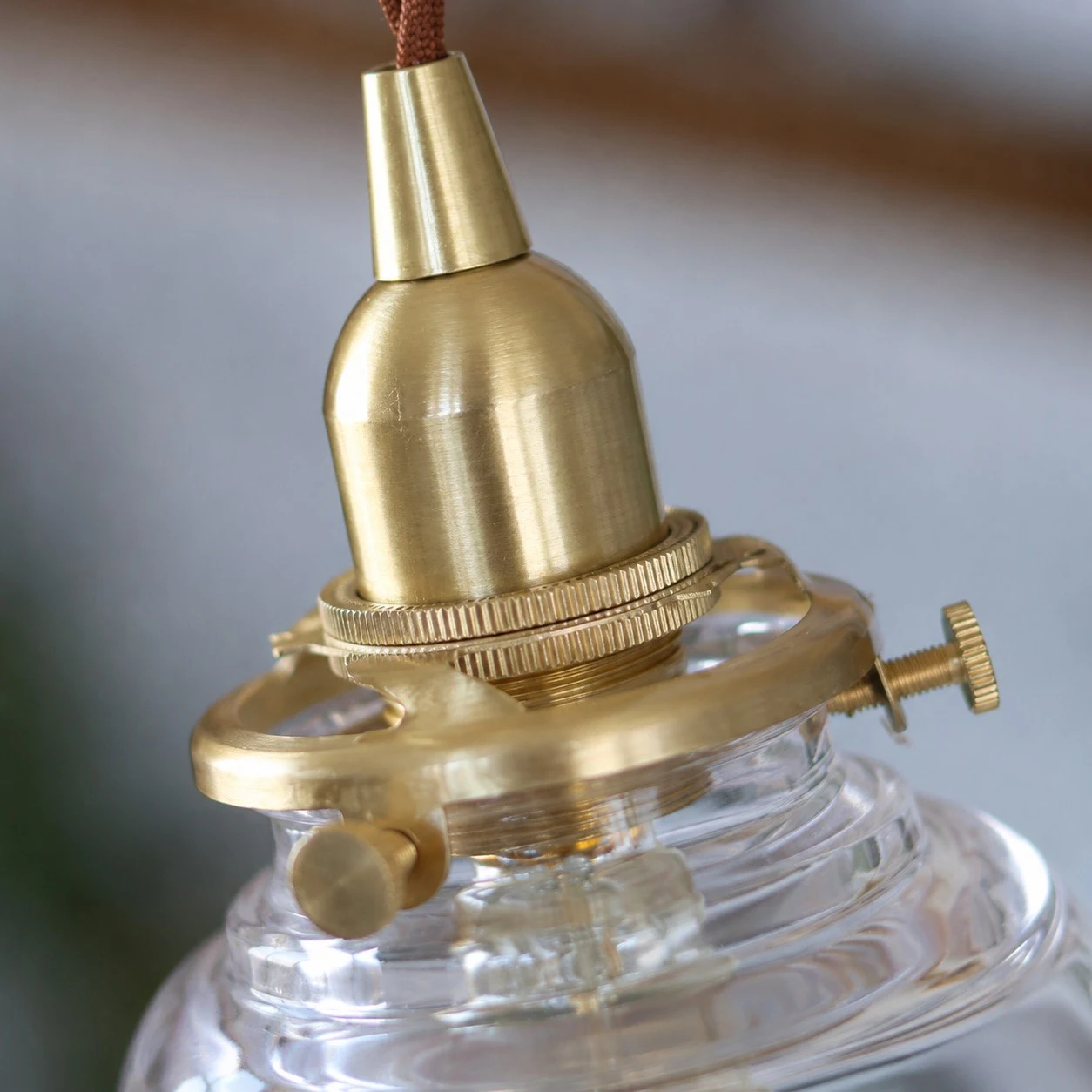 Brass glass pendant light installed over a kitchen counter