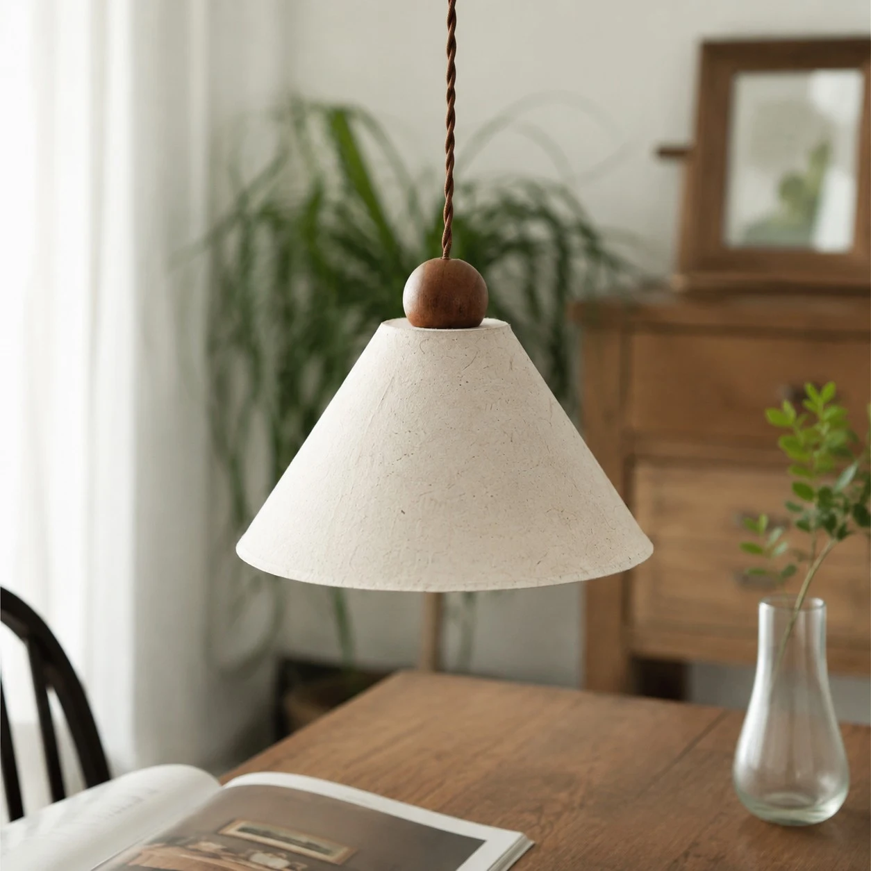 Natural paper pendant lamp over a dining table