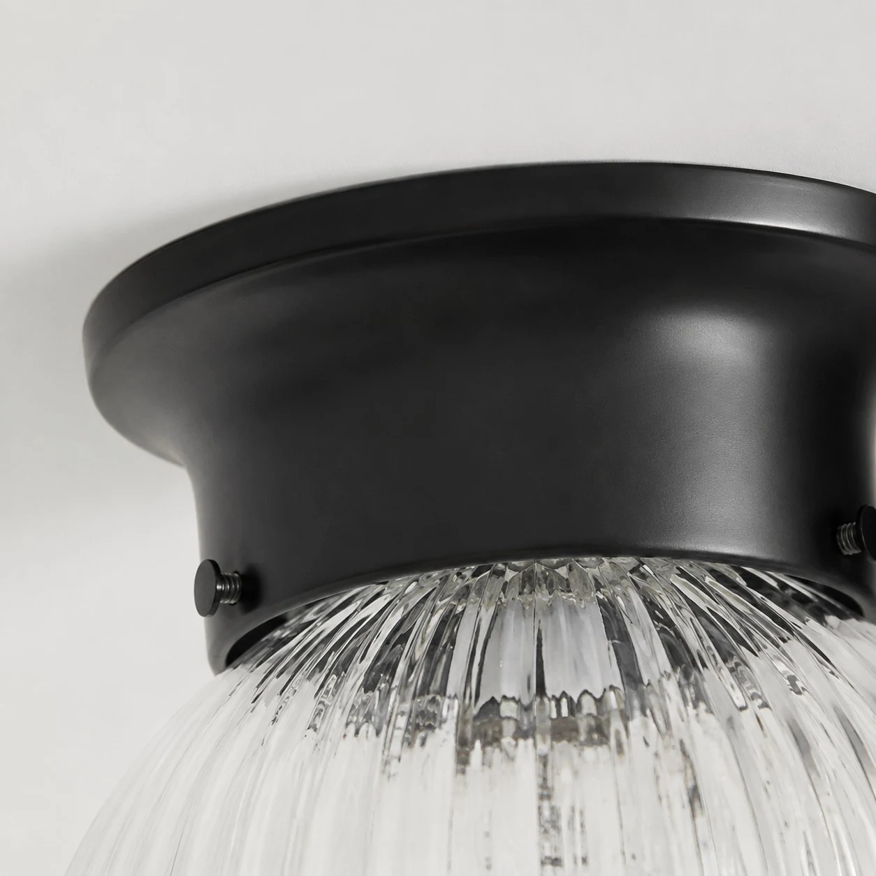 Close detail of black metal ceiling canopy and glass shade connection