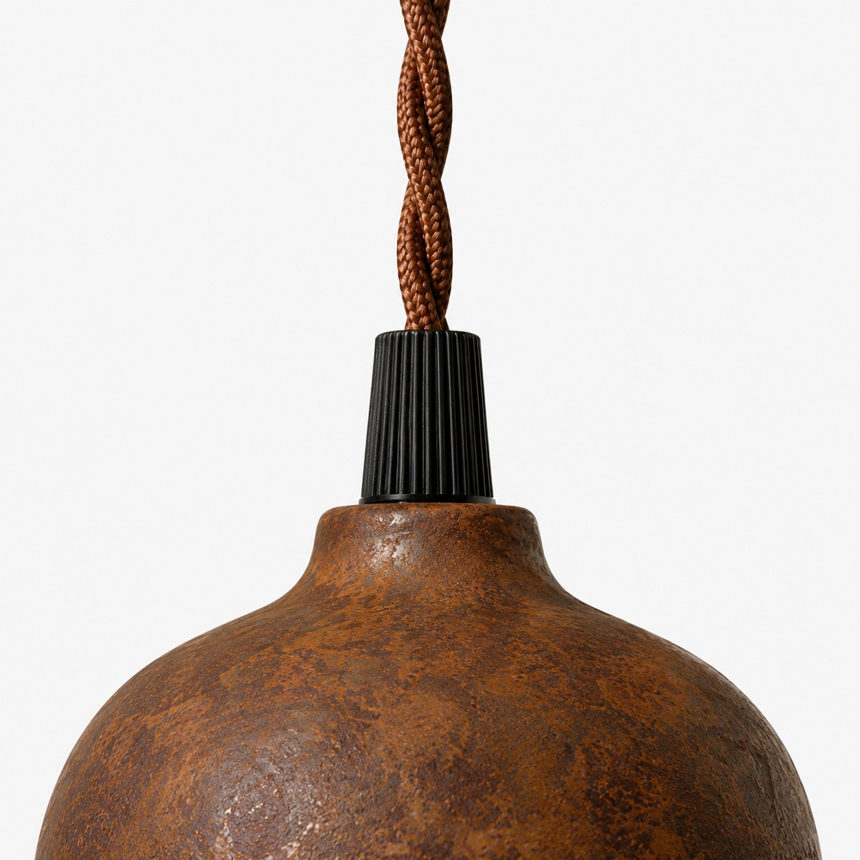 Close-up of black cord holder and braided cord above rust shade