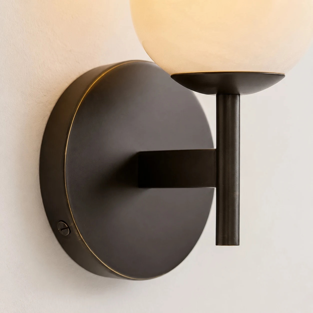Close detail of black finish round canopy and wall arm