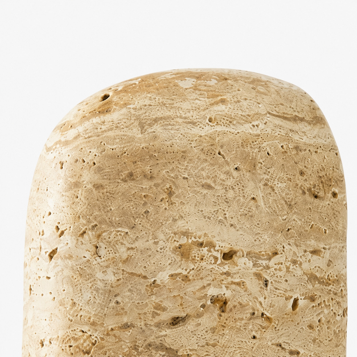 Close detail of rounded travertine shade top with natural stone holes and grain