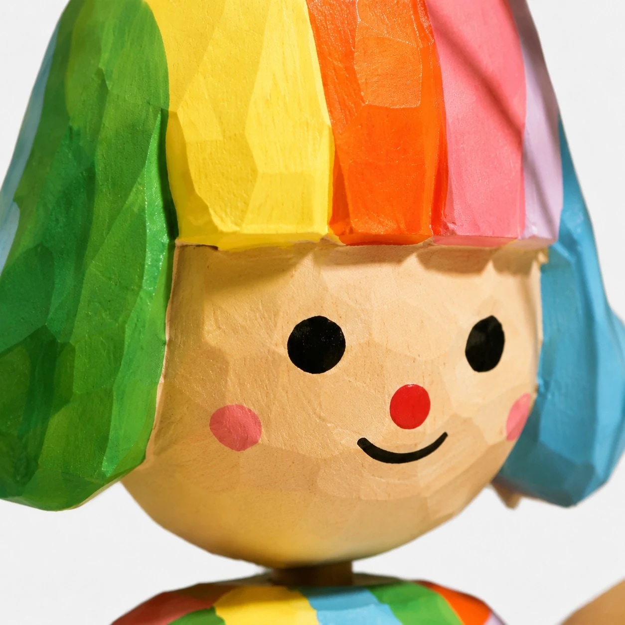 Painted face detail on wooden figurine
