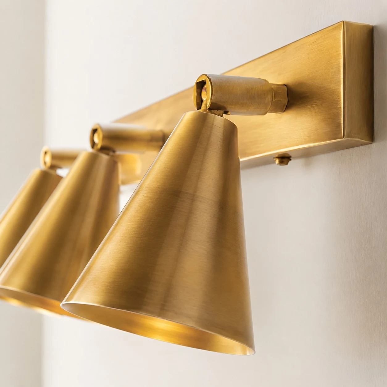 Angled detail of brass double cone wall light