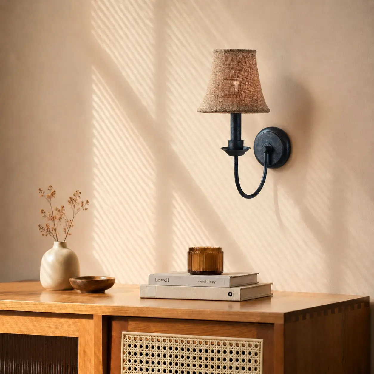Fabric wall sconce above a warm wood console