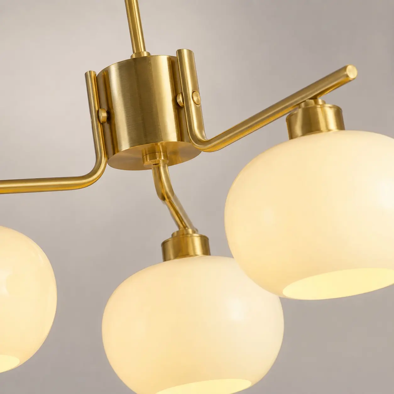 Gold chandelier arm connection and milk glass shade detail