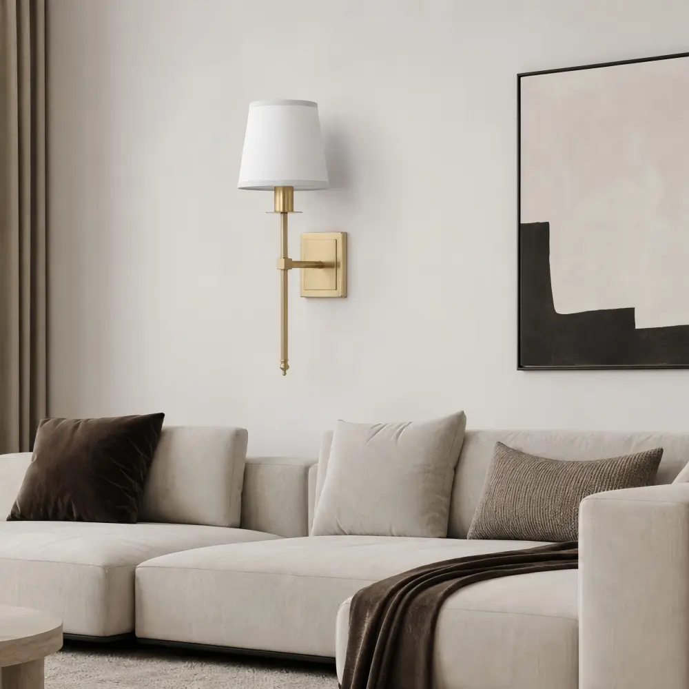 Single Head brass wall sconce above a light sofa in a warm living room