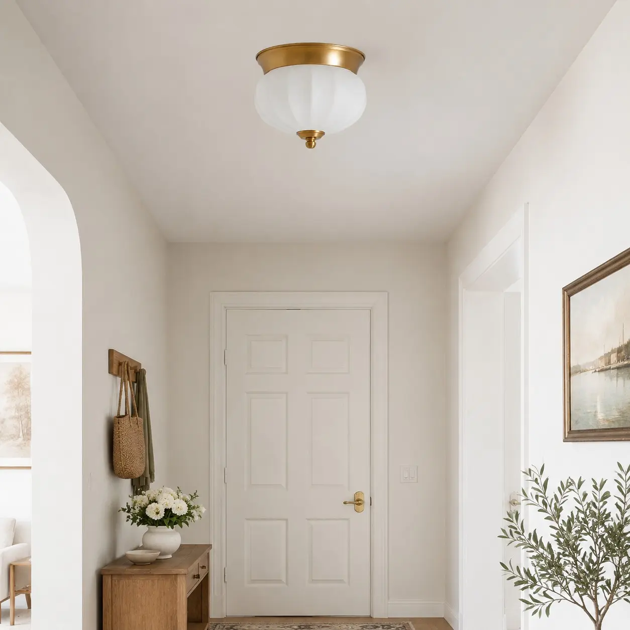 Compact brass and glass flush mount in a bright entry