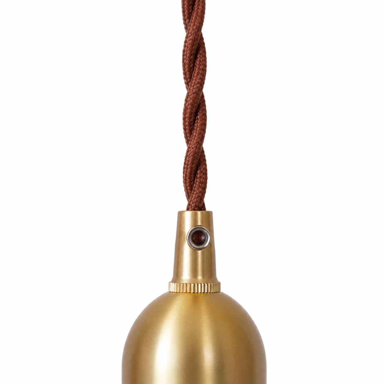 Close up of braided textile cord and brass tone lamp holder