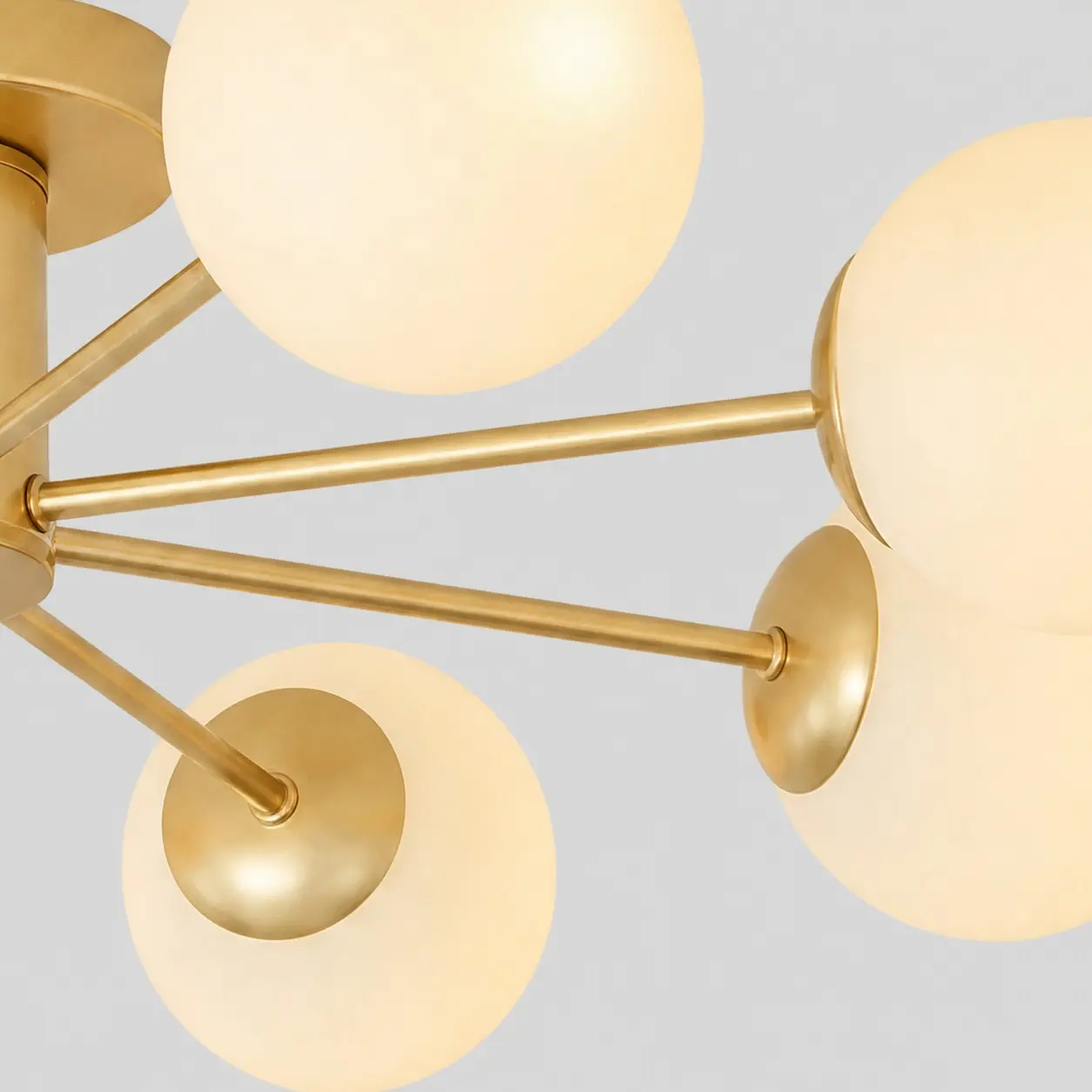 Close-up of the gold arms and glass globe shades