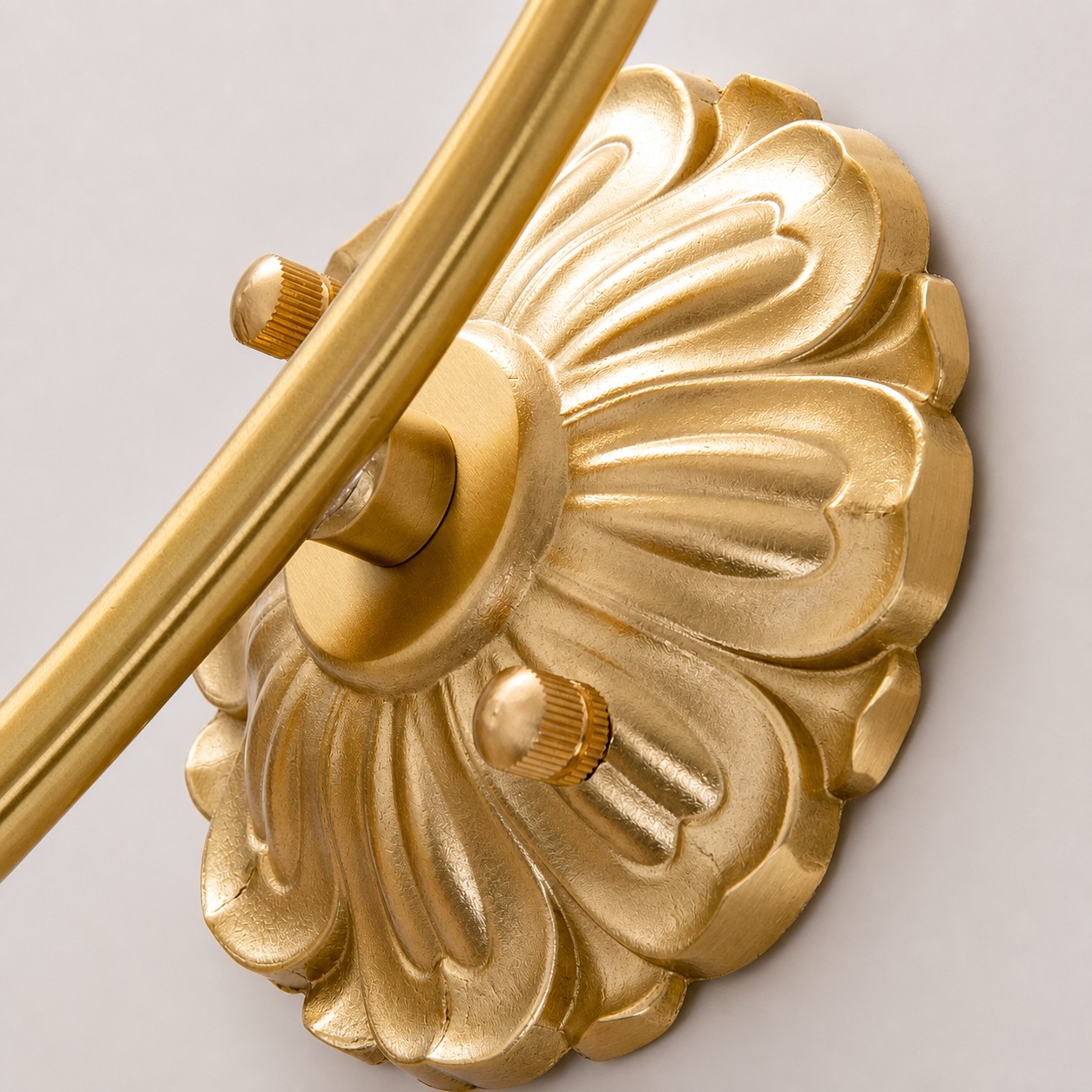 Close-up of sculpted wall plate and arm connection