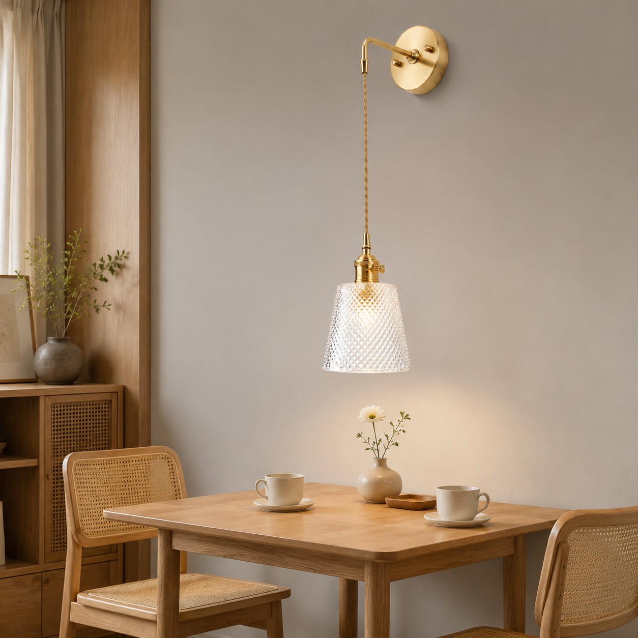 Brass and clear glass wall light installed beside a dining table