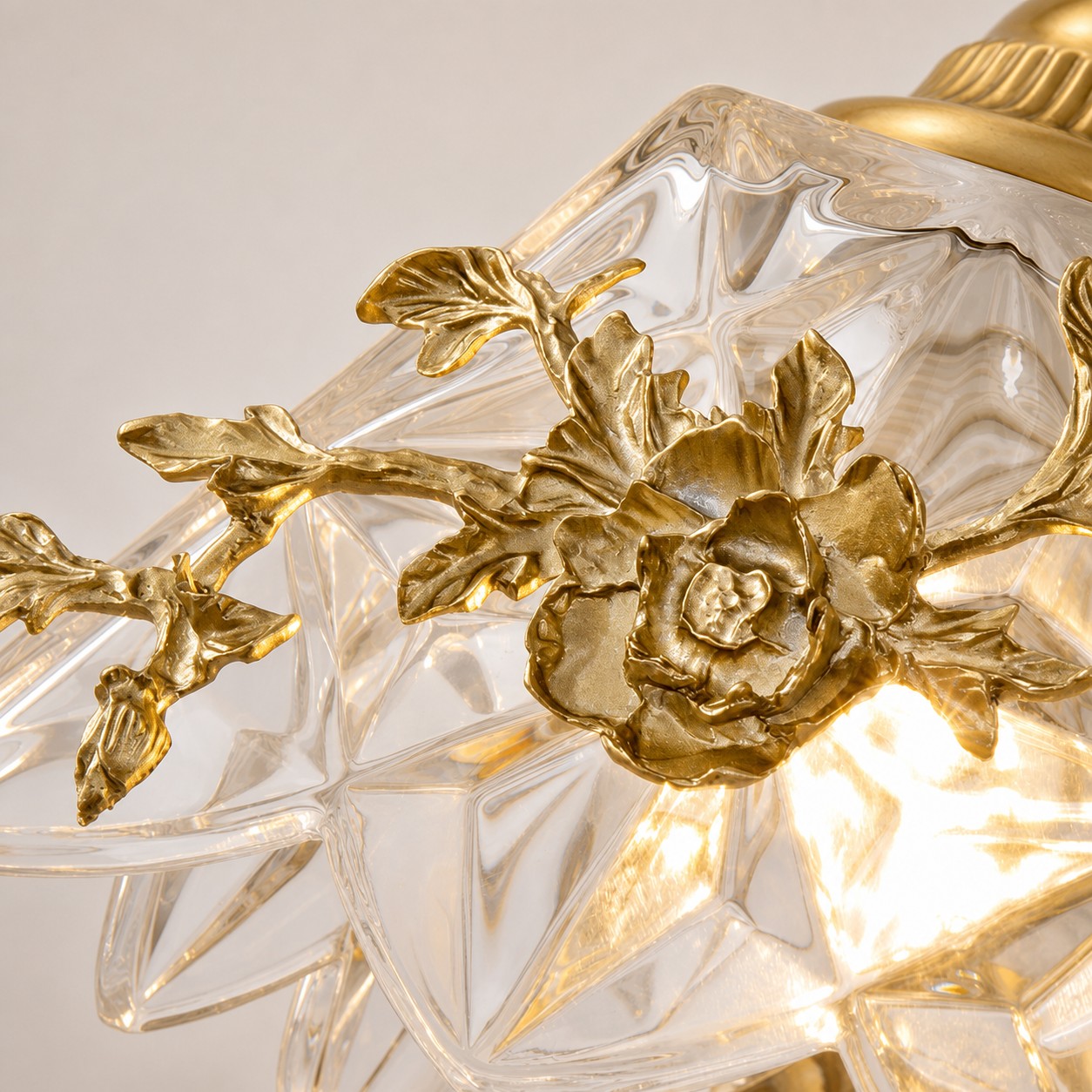 Close-up of floral glass shade and brass-tone flower detail