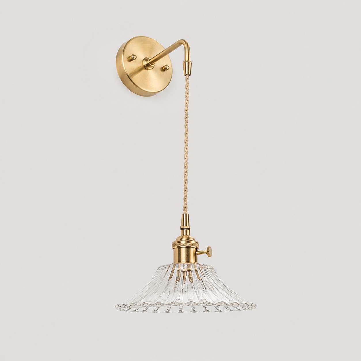 Clear shallow glass wall light with brass arm, W shade 6 cm high and 18 cm diameter