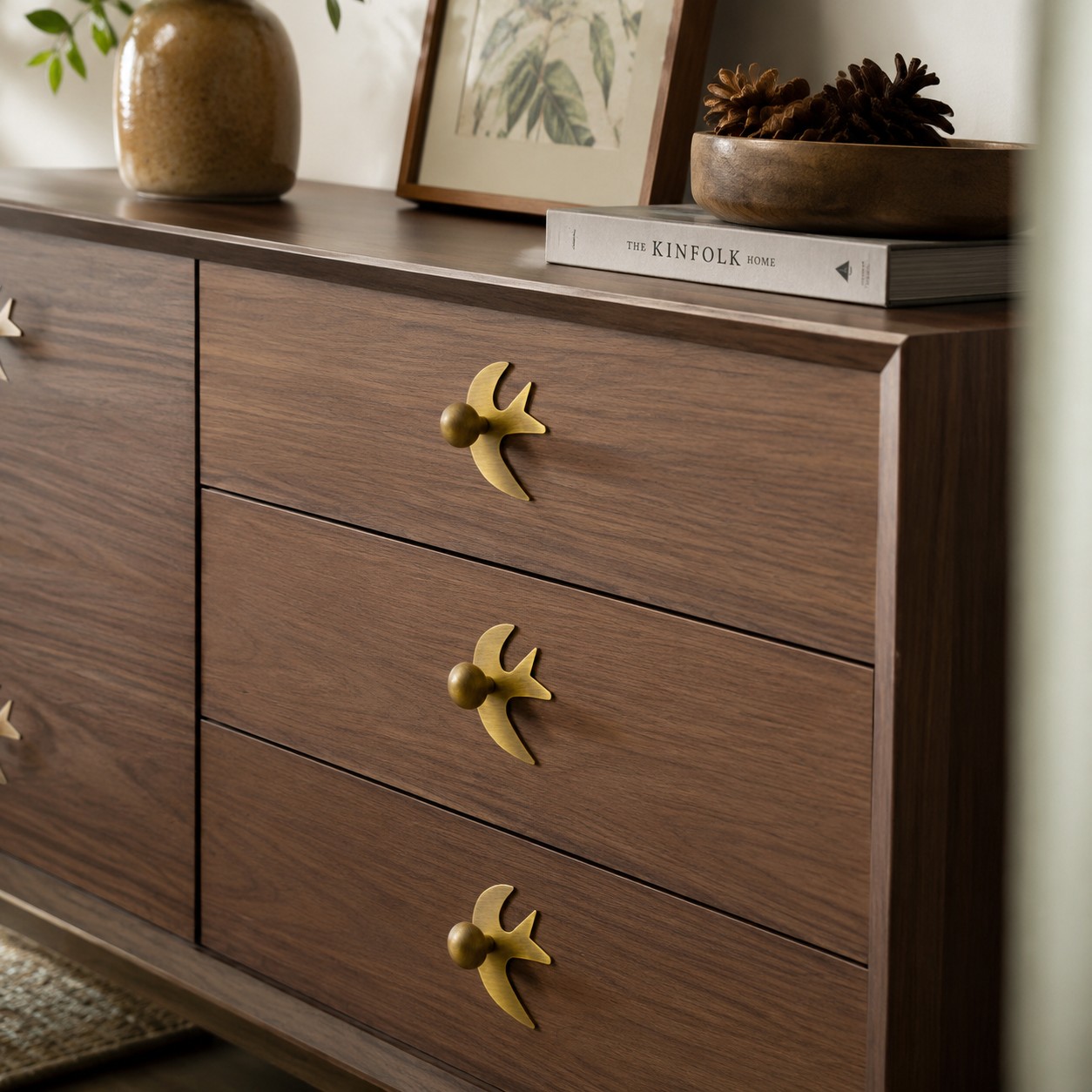 Antique brass swallow handles on a wood dresser