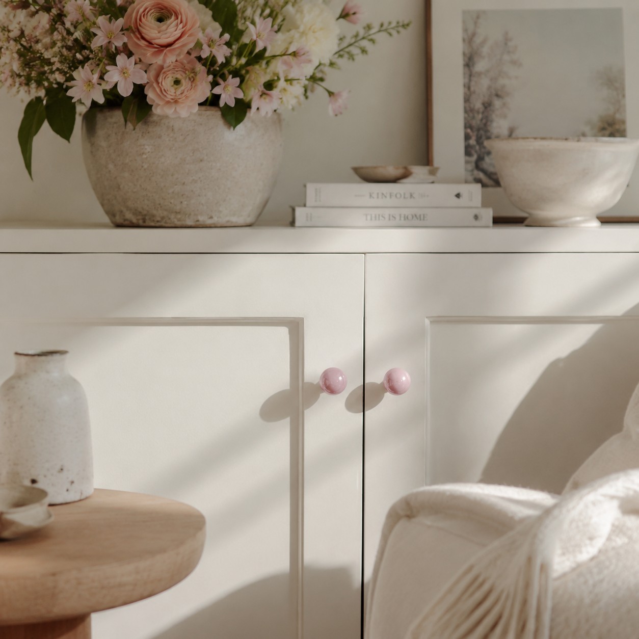 Blush pink cabinet knobs on a styled cabinet