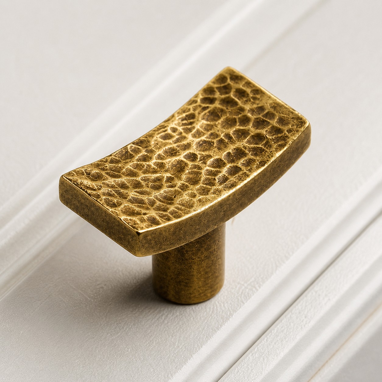 Hammered brass cabinet knob with curved profile