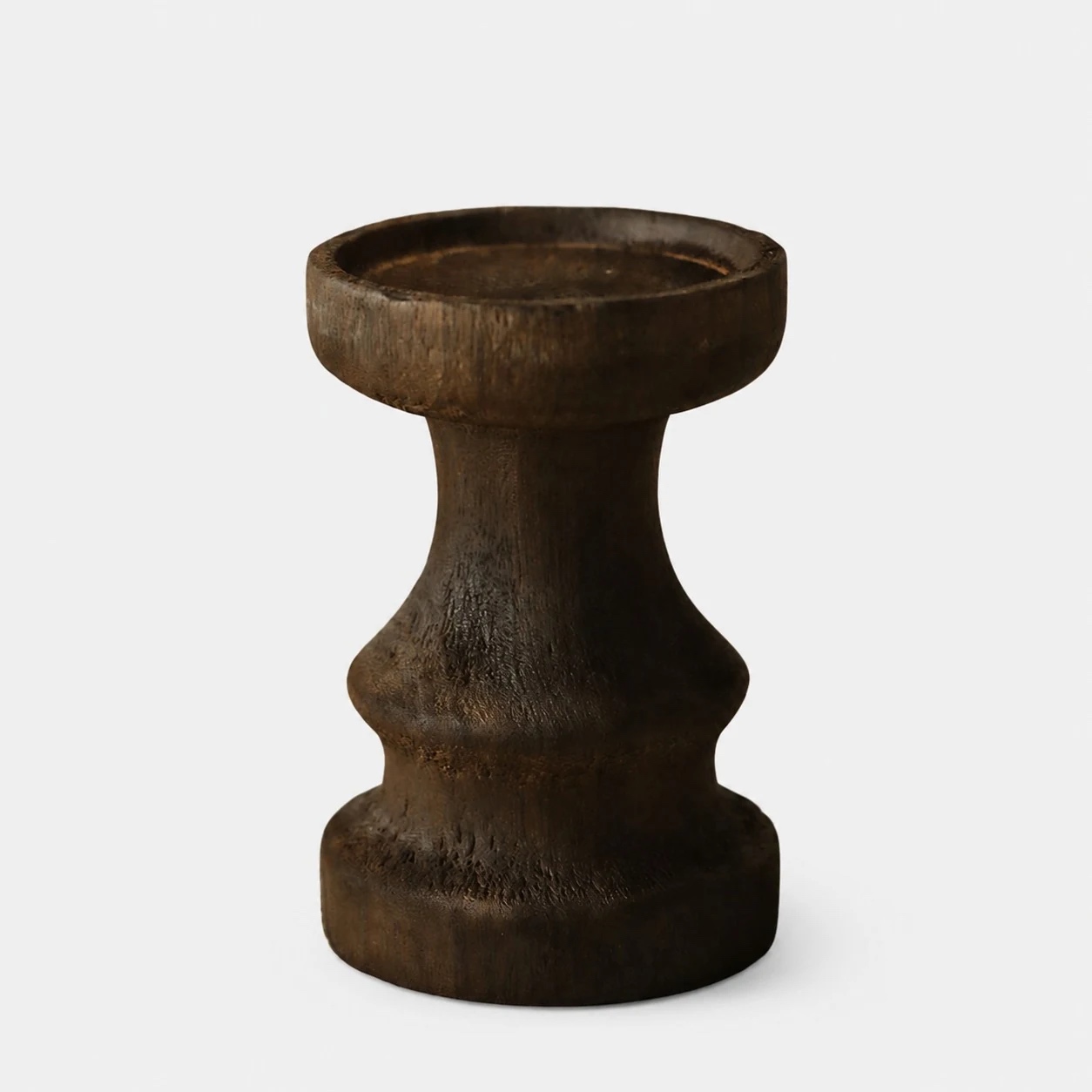 Short dark solid wood candle holder on a neutral background