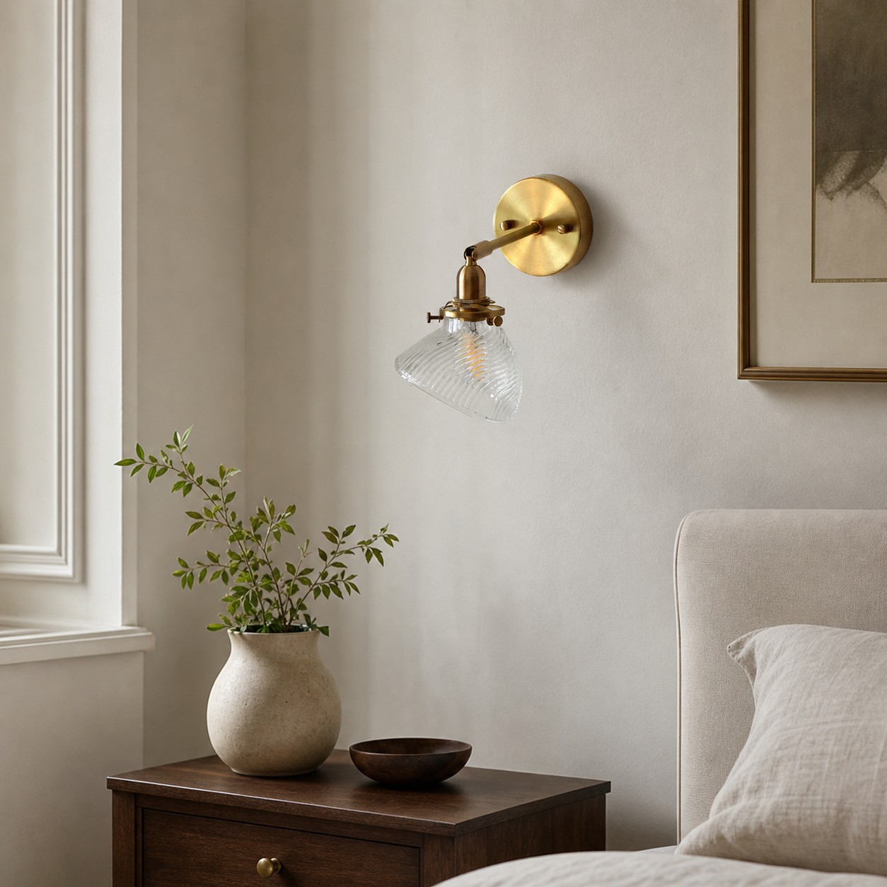 Clear glass wall lamp installed beside a bed