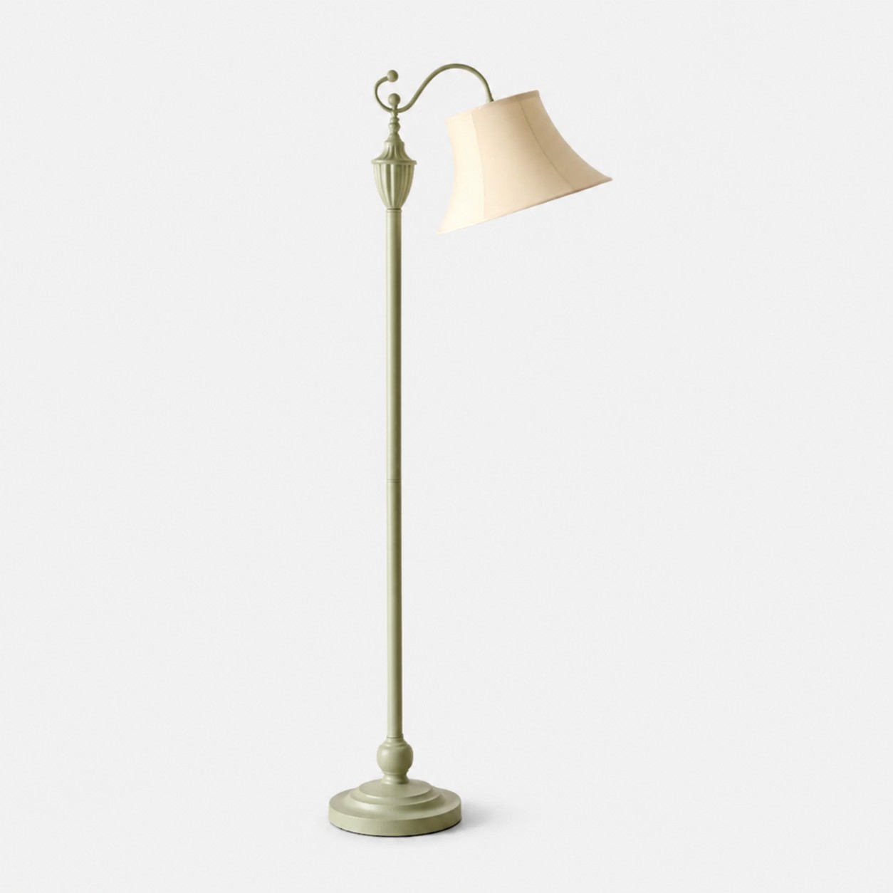 Sage green curved-arm floor lamp with ivory fabric shade on a light background