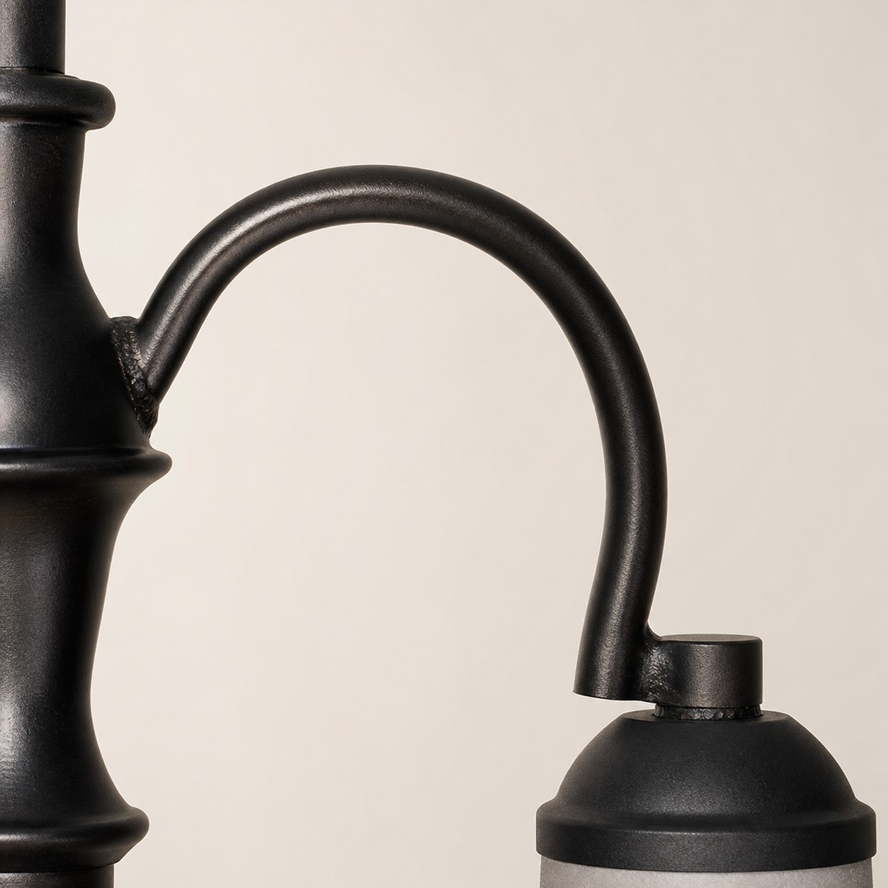 Close view of curved black iron chandelier arm