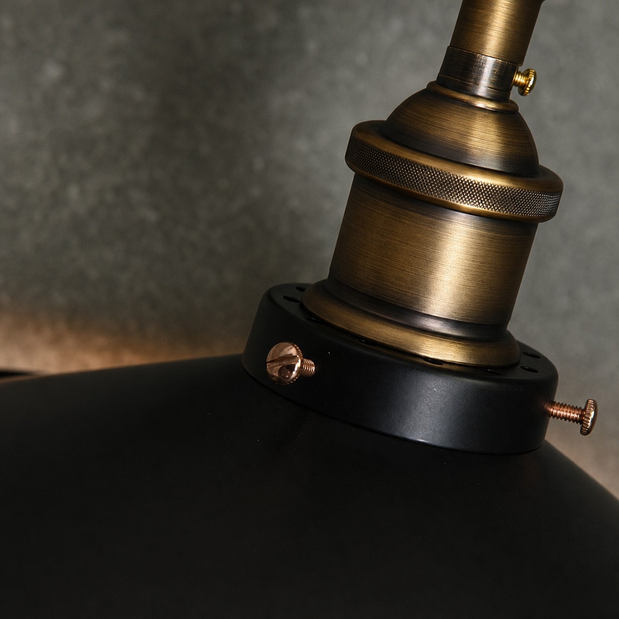 Close-up of antique brass-tone metal lamp holder and black shade