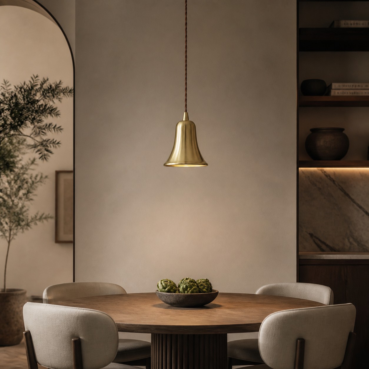 Bell-shaped natural brass pendant light in a warm dining room