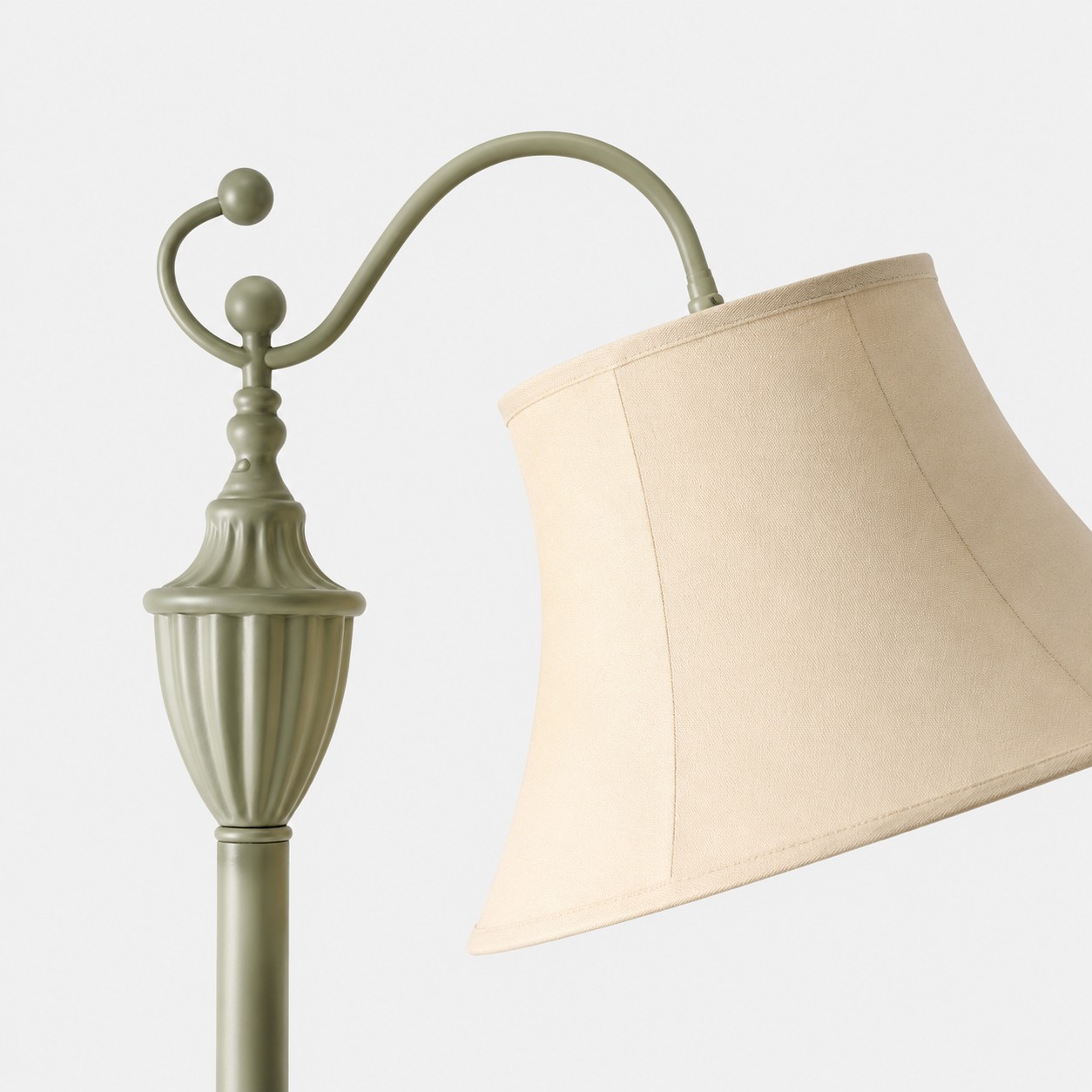 Curved arm ornament and ivory fabric shade detail